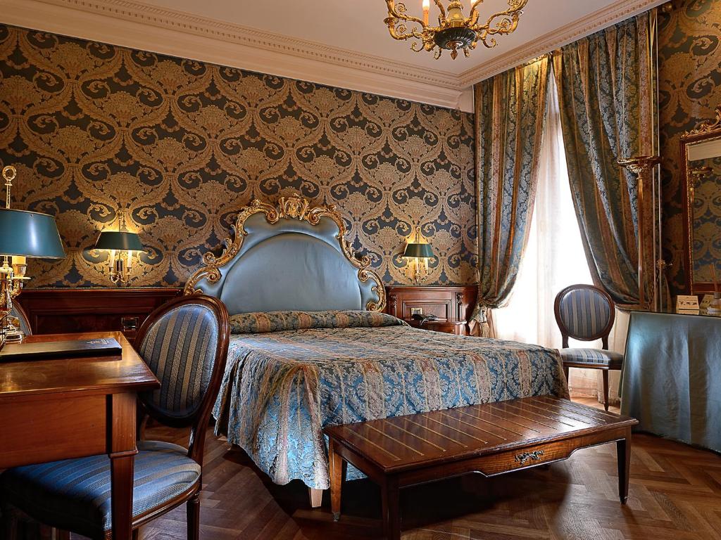 sypialnia z łóżkiem, stołem i krzesłami w obiekcie Bellevue Luxury Rooms - San Marco Luxury w Wenecji