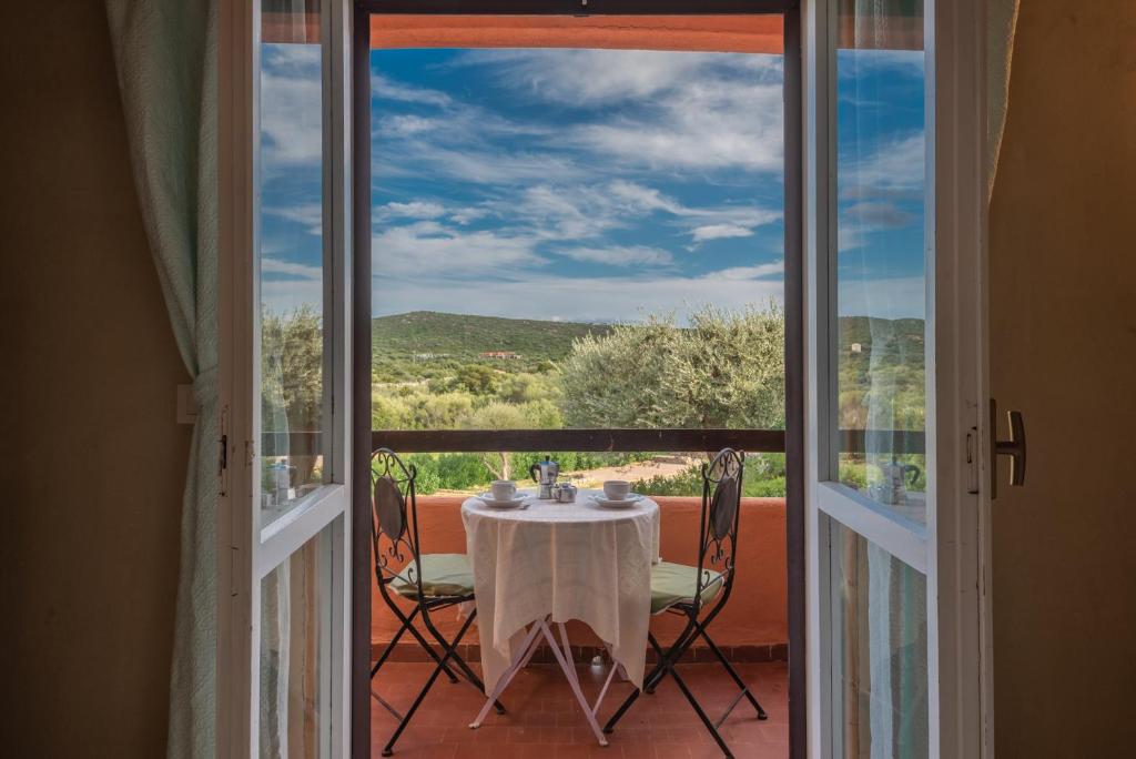 ein Tisch und Stühle auf einem Balkon mit Aussicht in der Unterkunft Baia de Bahas Residence in Golfo Aranci