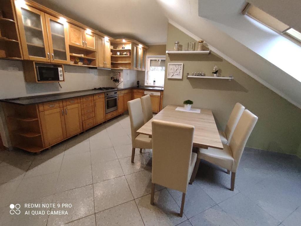 eine Küche mit einem Holztisch und Stühlen in der Unterkunft Felhő Apartman in Balatonfüred