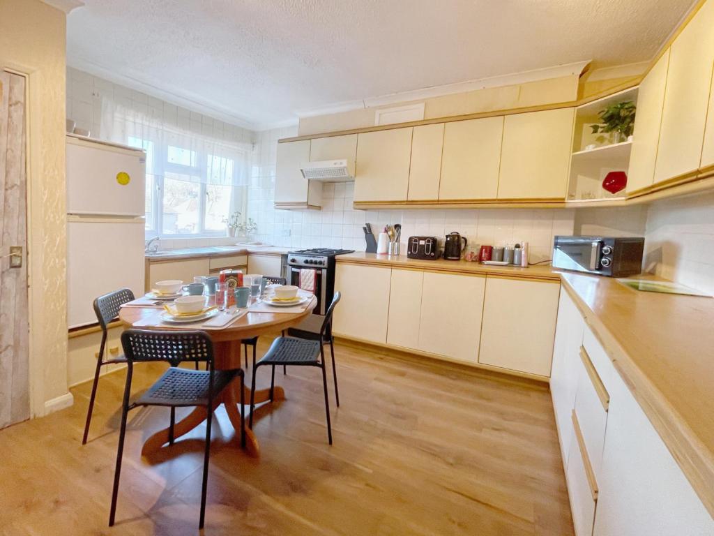 a kitchen with a table and chairs in it at 3 bed duplex flat, free WIFI & Netflix, Ideal for contractors in Gravesend