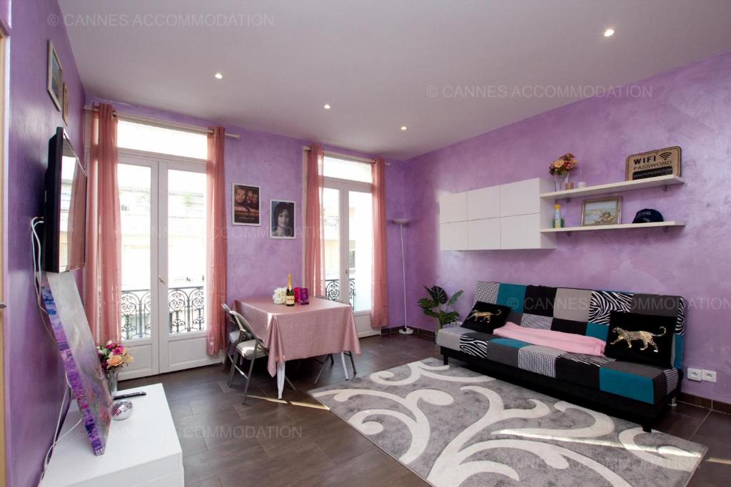 Cette chambre violette comprend un lit et une table. dans l'établissement Madeleine, à Cannes