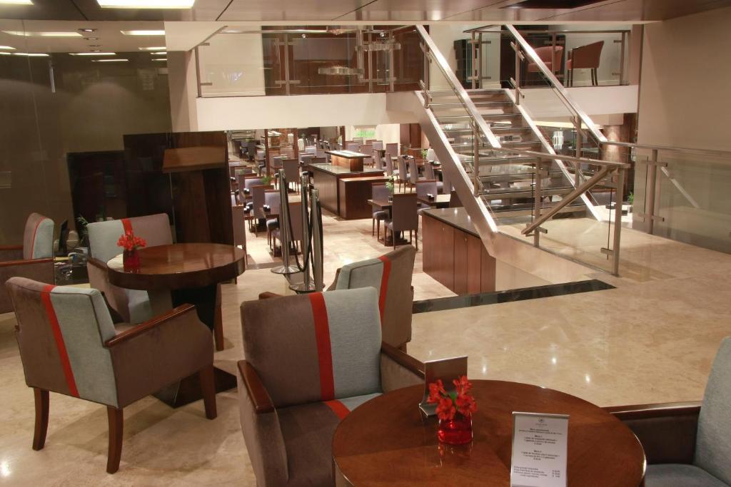 a restaurant with tables and chairs and a staircase at Grand King Hotel in Buenos Aires