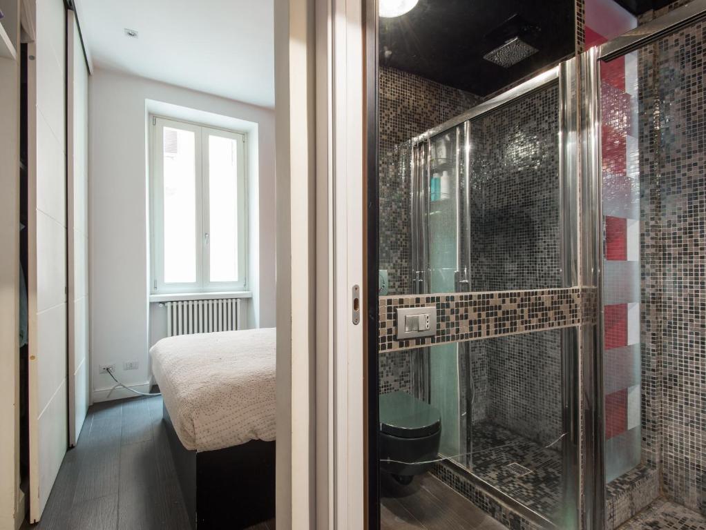 Pokój z prysznicem, łóżkiem i oknem w obiekcie Coronari Enchanting Two Bedroom w Rzymie