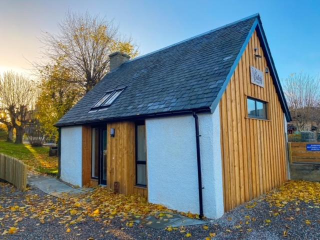 una piccola casa con tetto nero di Butterfly Cottage a Grantown on Spey