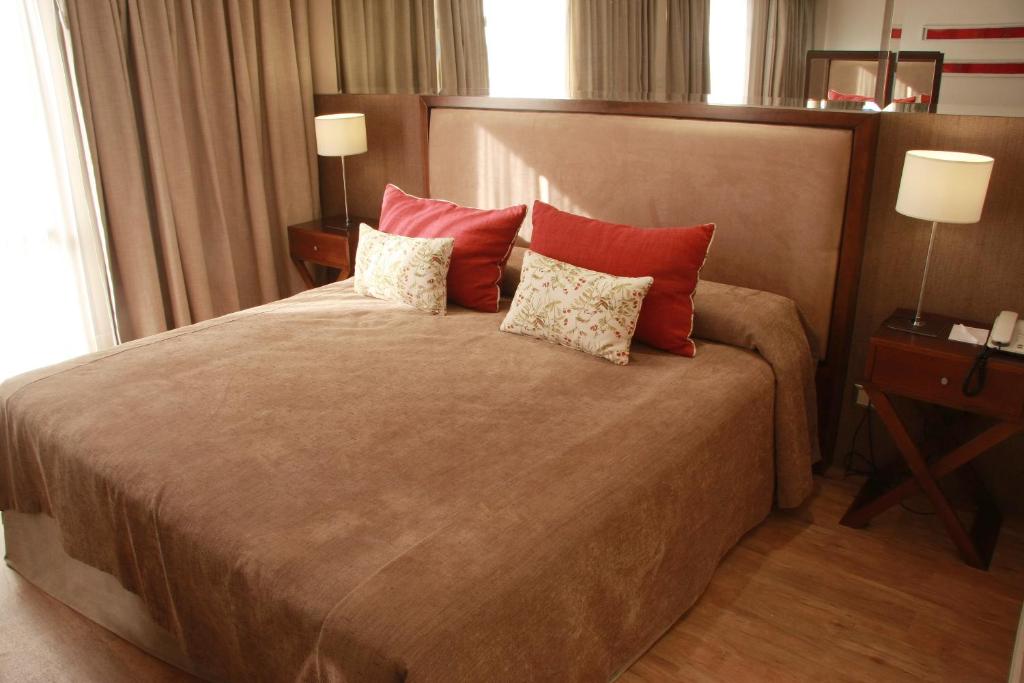 a bedroom with a large bed with red pillows at Grand King Hotel in Buenos Aires