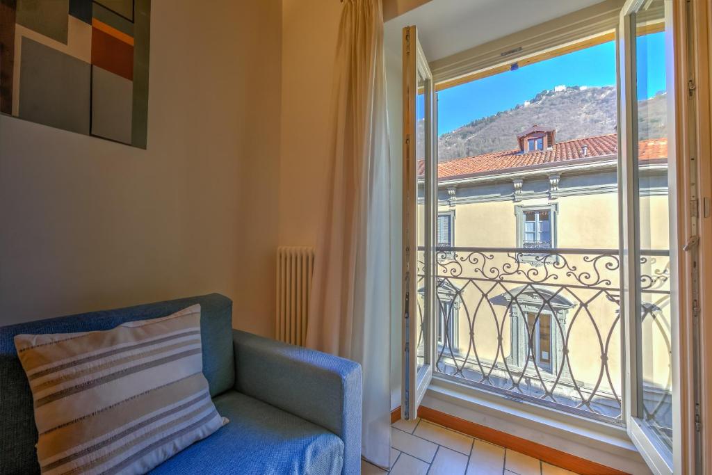 een woonkamer met een bank en een groot raam bij Le Stanze del Lago Apartments in Como