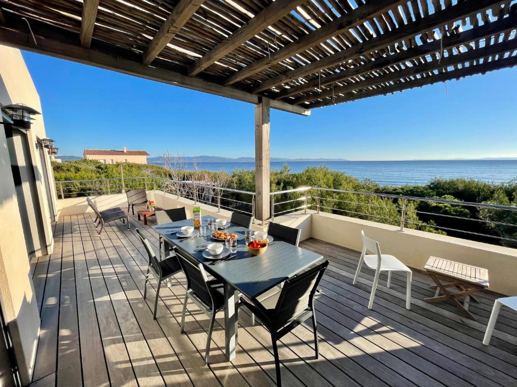 un patio avec une table et des chaises sur une terrasse dans l'établissement Appartement luxe Le Levant, à Hyères