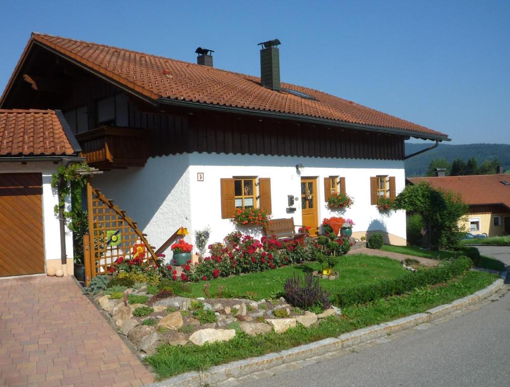 ein weißes Haus mit einem Garten davor in der Unterkunft Ferienwohnung Irene in Zwiesel