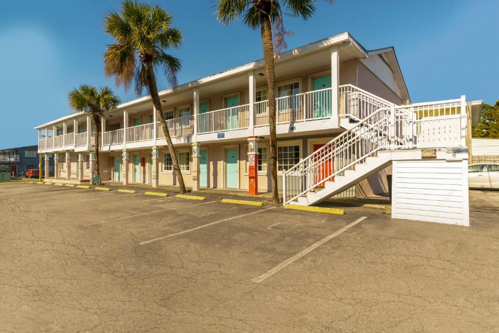 un edificio con palmeras en un aparcamiento en OYO Hotel Myrtle Beach Kings Hwy en Myrtle Beach