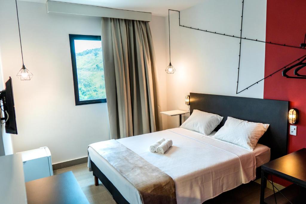 Una habitación de hotel con una cama con una toalla. en Front Comfort Teófilo Otoni, en Teófilo Otoni