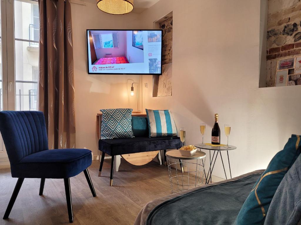 a bedroom with a bed and a tv on the wall at L établissement LA PLAGE A 2 PAS vous propose, 3 Appartements DEUX chambres, 1 appartement une pièce avec CLIMATISEUR , Netflix, lits faits à votre arrivée, serviettes de toilette, Ménage, Wifi, en hyper centre ,Plage à 100m, BOX à Vélos in Dieppe