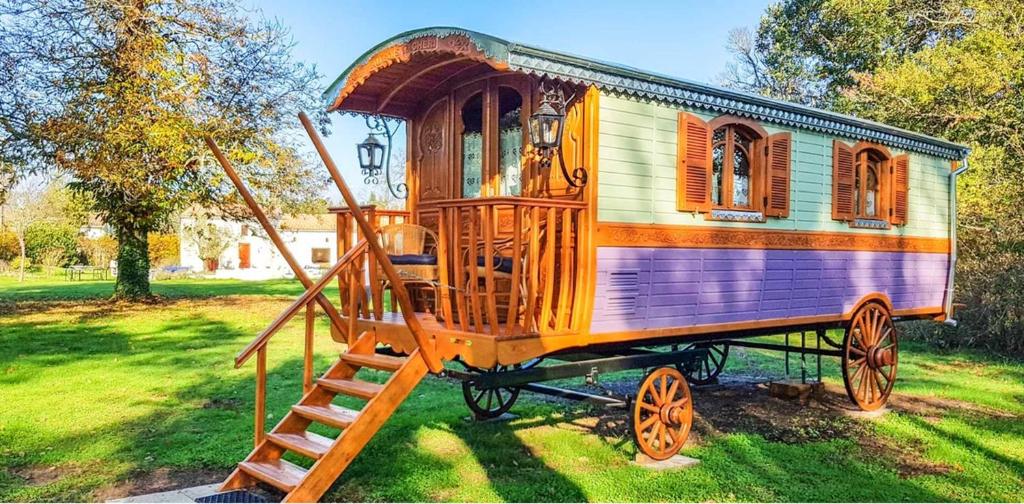un wagon en bois avec une échelle sur l'herbe dans l'établissement Studio cosy à Bussac-Forêt avec piscine partagée, 15m², à Bussac-Forêt