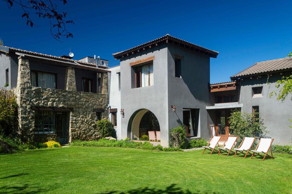 um grupo de cadeiras no pátio de uma casa em Aldebaran Hotel & Spa em San Carlos de Bariloche