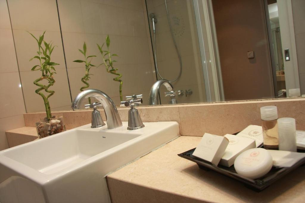 a bathroom with a sink and a mirror at Grand King Hotel in Buenos Aires
