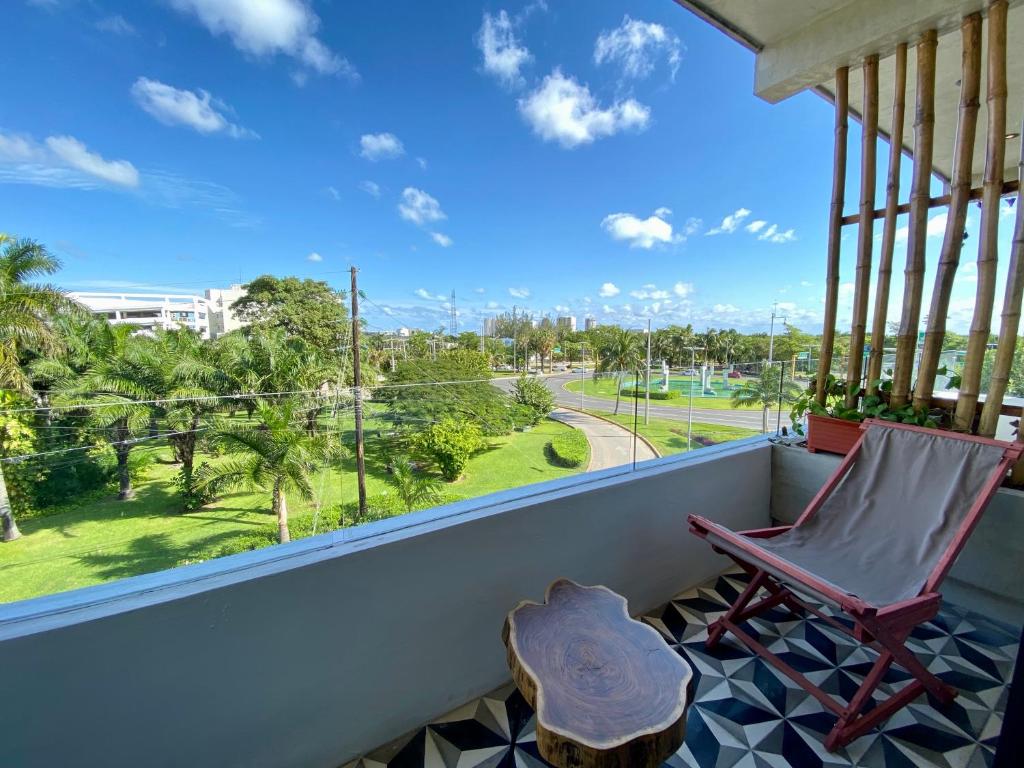 a rocking chair on a balcony with a view of a street at Coba Studios in Cancún