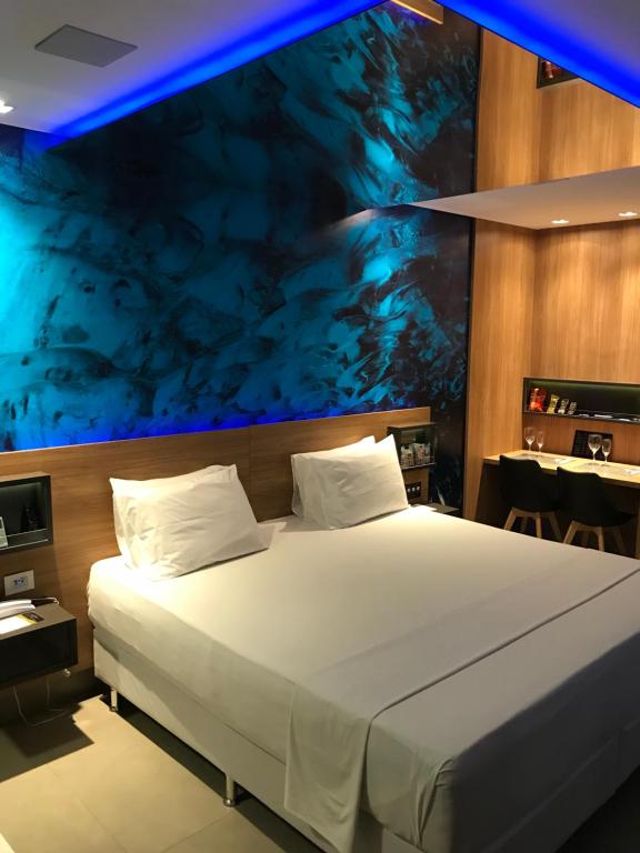 um quarto com uma cama grande e um tecto azul em Fantasy Motel em Salvador