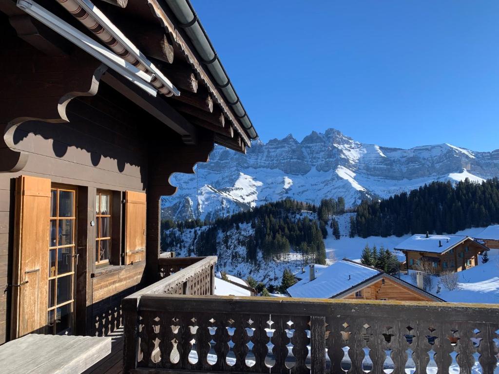 uma varanda com vista para uma montanha nevada em Chalet à la montagne em Champoussin