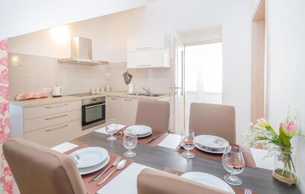a kitchen with a table with chairs and a dining room at Apartman Ivano in Pula