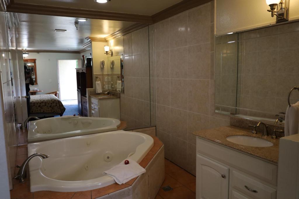 a bathroom with two sinks and a bath tub at Lambert Inn in Whittier