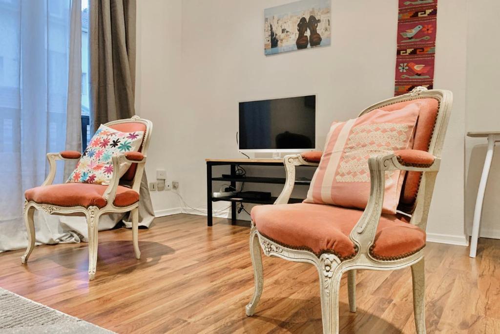 a living room with two chairs and a television at In the heart of Grenoble #CO in Grenoble