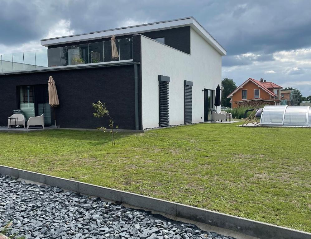 a white and black house with a yard at Strandkieker 4 nur 500m zum Strand in Ueckermünde