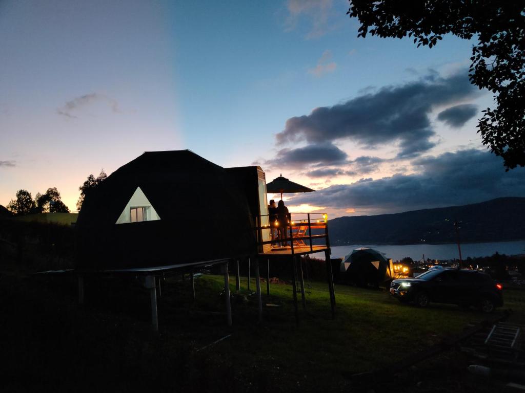 a person standing on a play structure with an umbrella at Glamping Amaru in Guatavita