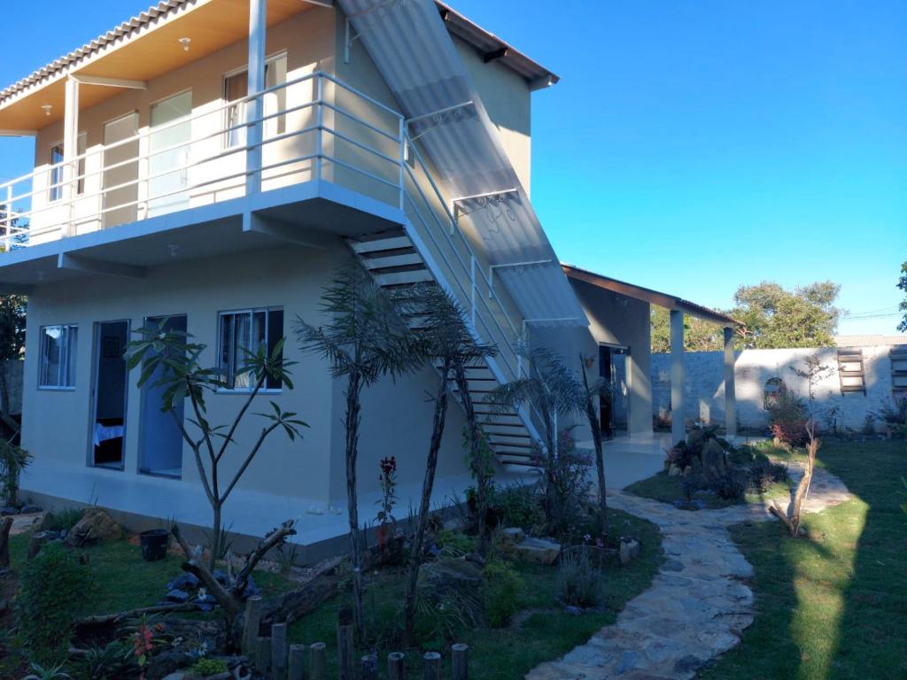 a house with a staircase leading up to a balcony at Pousada Ostara in Alto Paraíso de Goiás