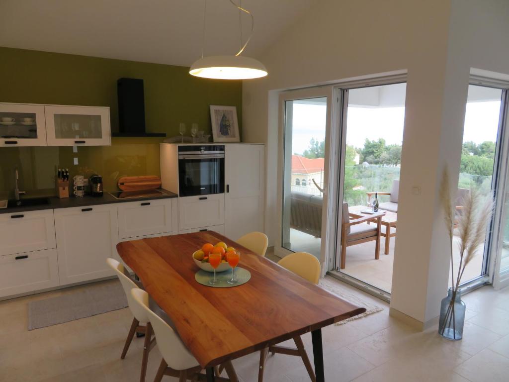una cucina con tavolo in legno e ciotola di frutta di Korčula - apartman 1, Prigradica - IVAN a Blato