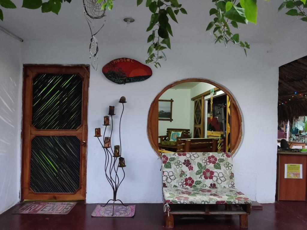 Habitación con silla y espejo. en Hostal Corazón de Tagua en Palomino