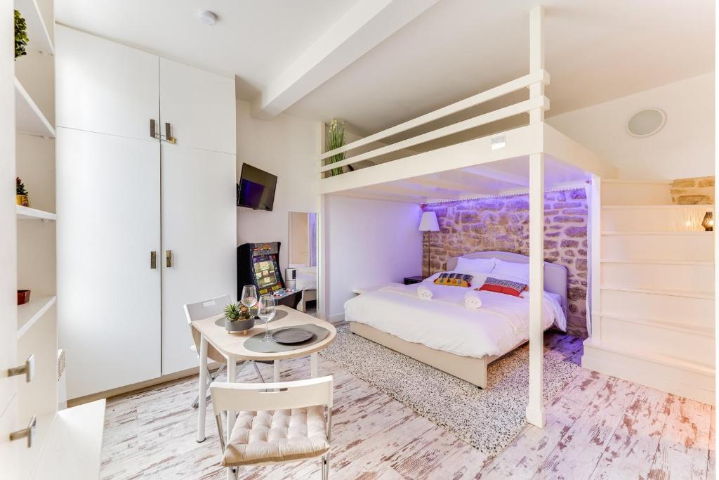 a bedroom with a bunk bed and a desk and a table at L'emplacement Idéal - Tour Eiffel 10min - NETFLIX - in Paris