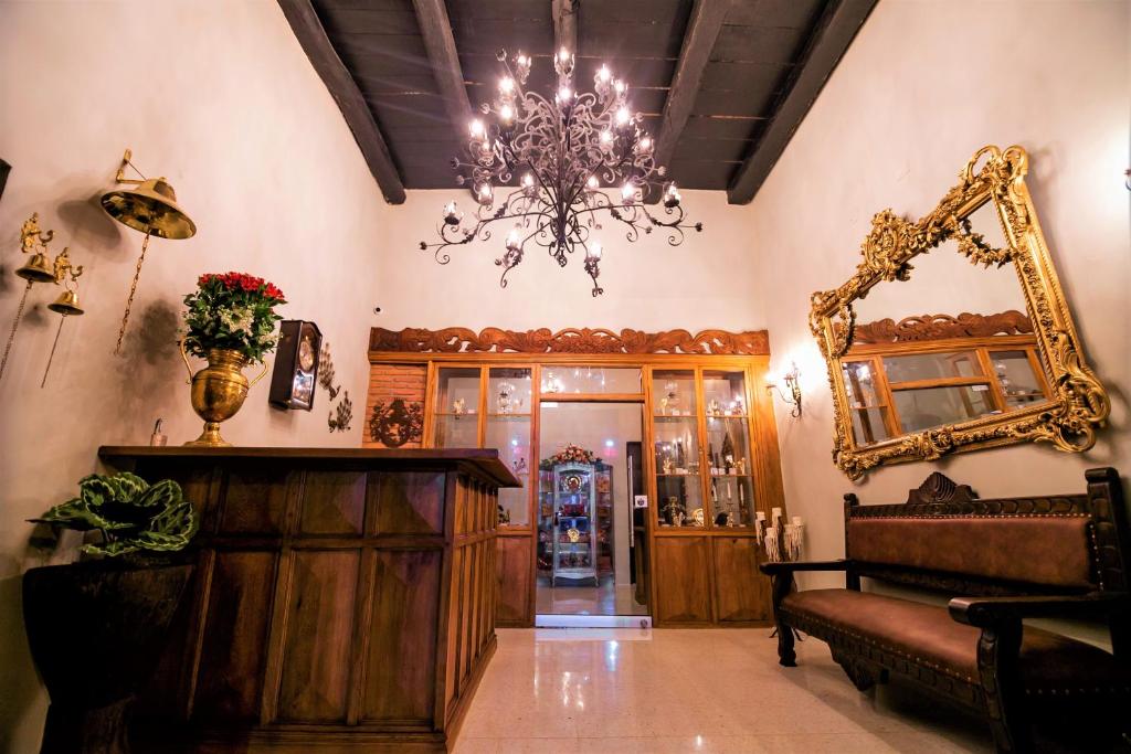 ein Wohnzimmer mit einem Spiegel und einem Kronleuchter in der Unterkunft Scalea Di Mare Hotel in Cartagena de Indias
