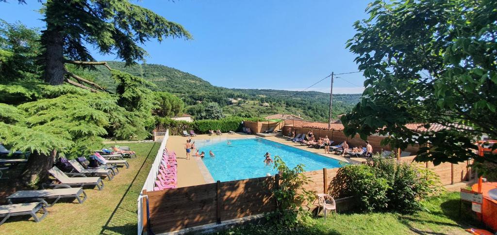 a large swimming pool with people sitting around it at Camping Les Lavandes in Darbres