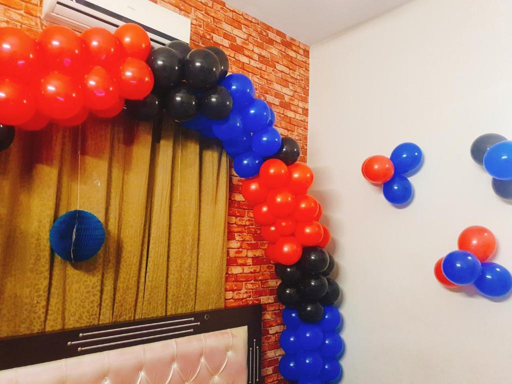 ein Zimmer mit einem Haufen Ballons und einem Fernseher in der Unterkunft Short Times Couple Guest House in Karatschi