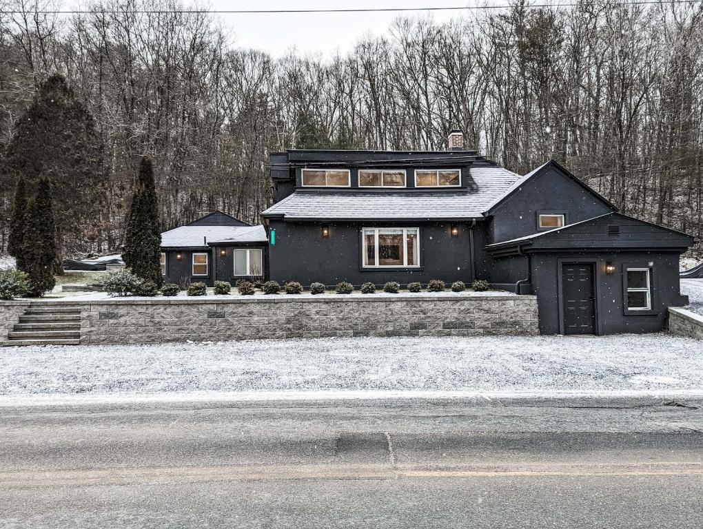 uma casa negra ao lado de uma rua em Hideaway Lodge - Glen Lake, Lake George em Lake George