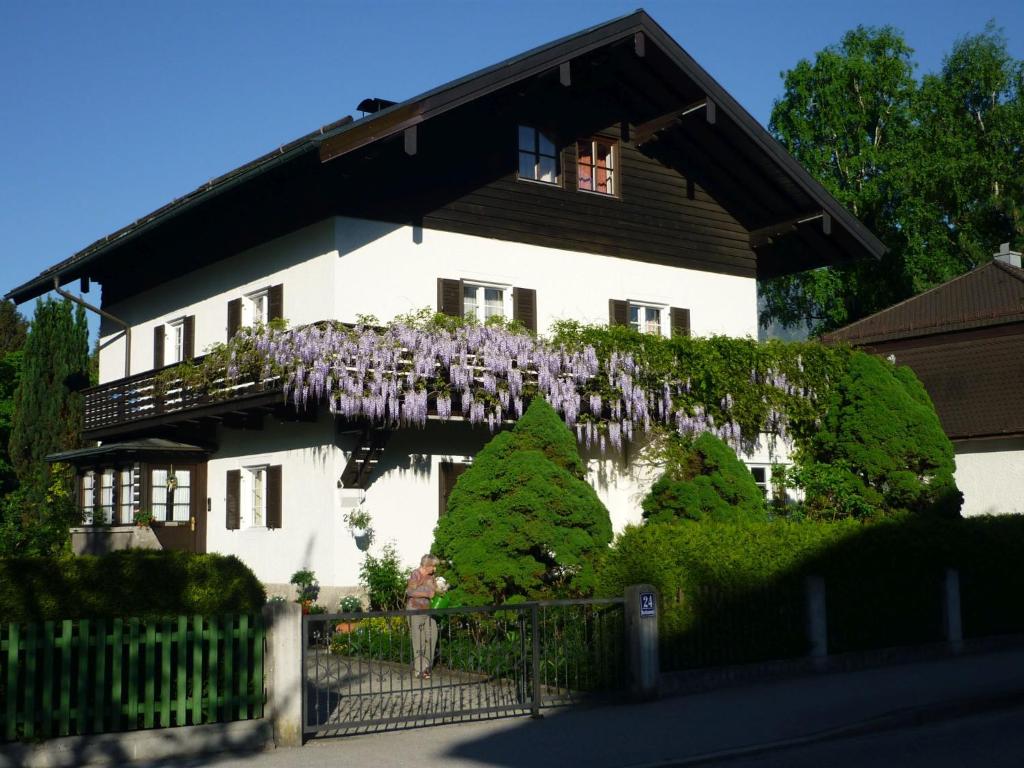 Una casa con flores púrpuras a un lado. en Ferienwohnung Sobotta, en Bad Reichenhall