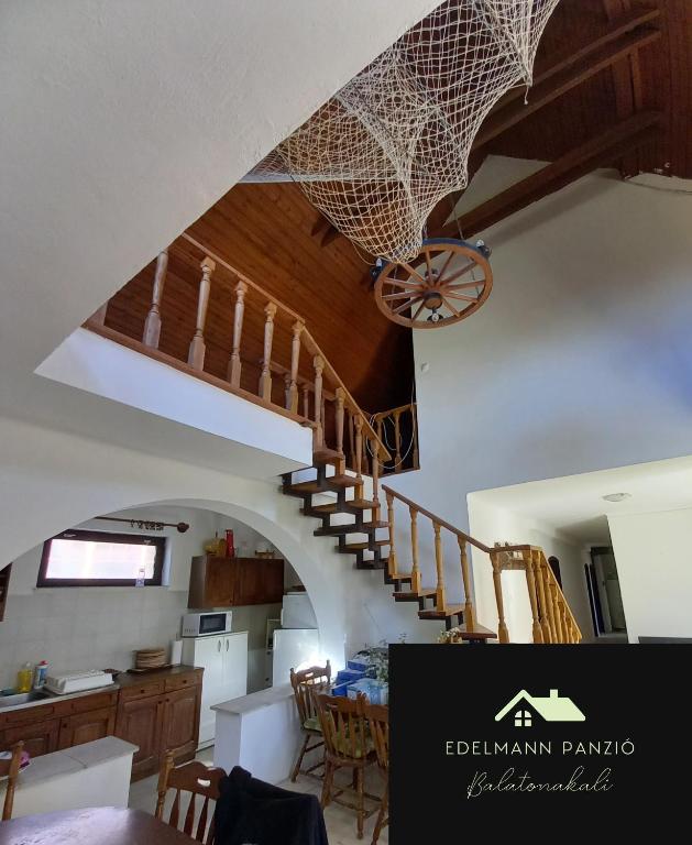 a kitchen and dining room with a staircase in a house at Edelmann Panzió in Balatonakali