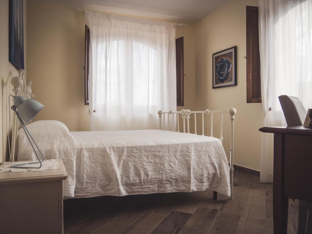 una camera con un letto bianco e una finestra di Agriturismo Ragozzino / De Marco a Pontelatone