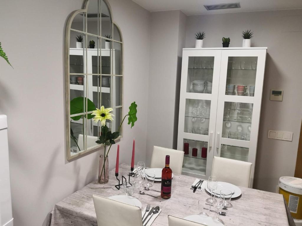 a dining room with a table with a bottle of wine at SeaHomes Vacations, BEACH&POOL, in Fenals Beach in Lloret de Mar