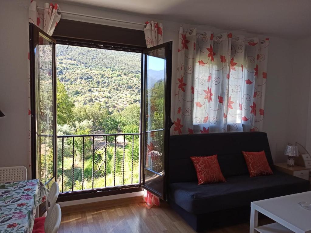 sala de estar con sofá y ventana grande en Casa Jimenez, en Güéjar-Sierra