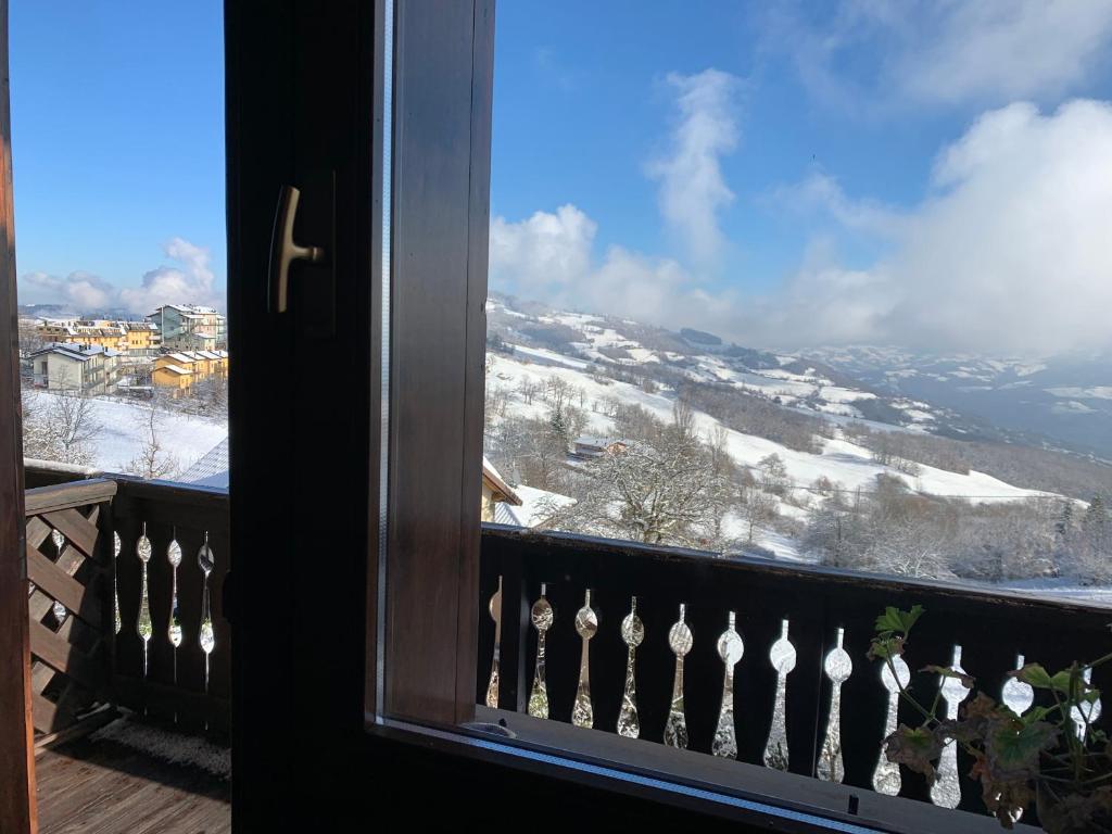 una finestra con vista su una montagna innevata di blu sky a Sestola