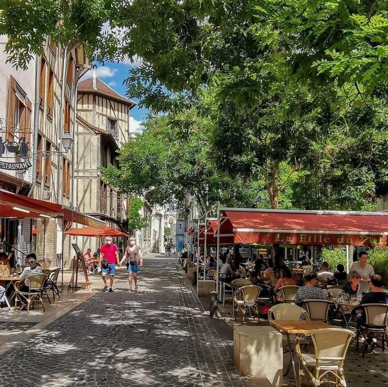 een straat met tafels en stoelen en mensen die over straat lopen bij Ô Cœur de Troyes - Bulles & Spa 4 étoiles in Troyes