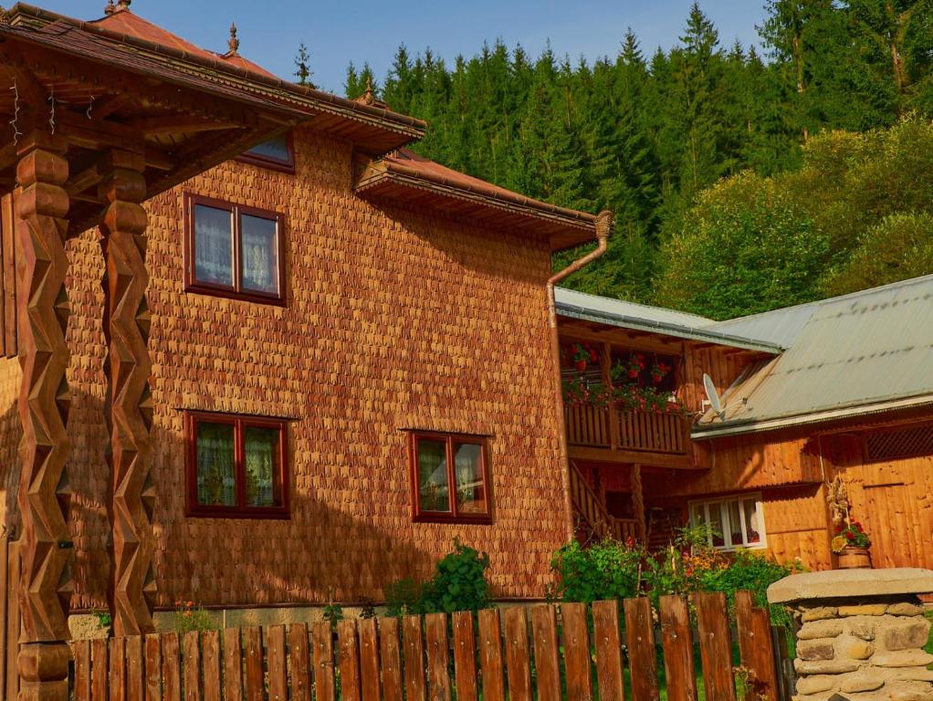 a wooden fence in front of a house at Pensiunea Agroturistica Casa Coliniţa in Vatra Moldoviţei