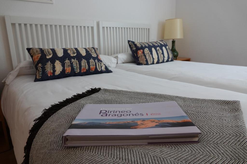 a book sitting on top of a bed at Huegas - A 90 metros del Reloj de Formigal in Formigal