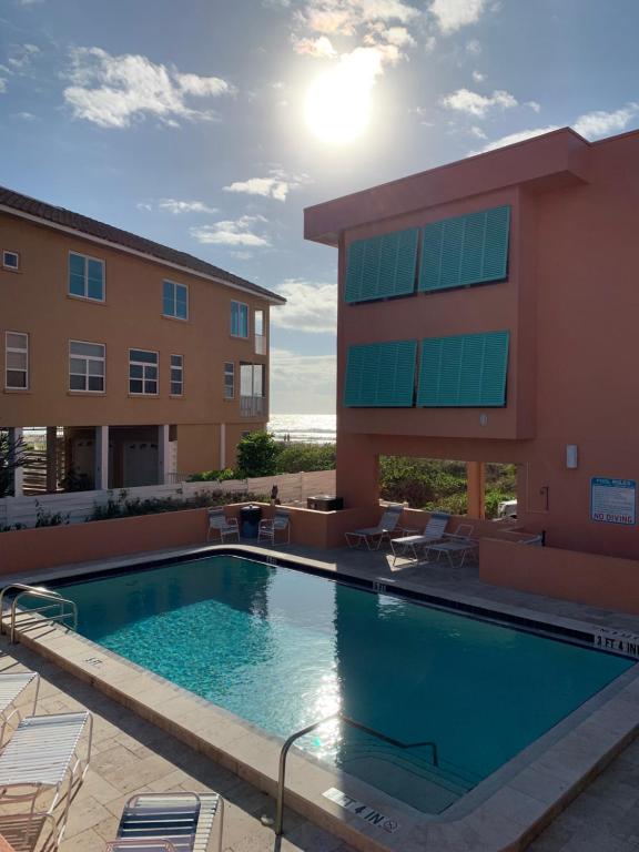 une piscine en face d'un bâtiment dans l'établissement Coquina Beach Club 109, à Bradenton Beach