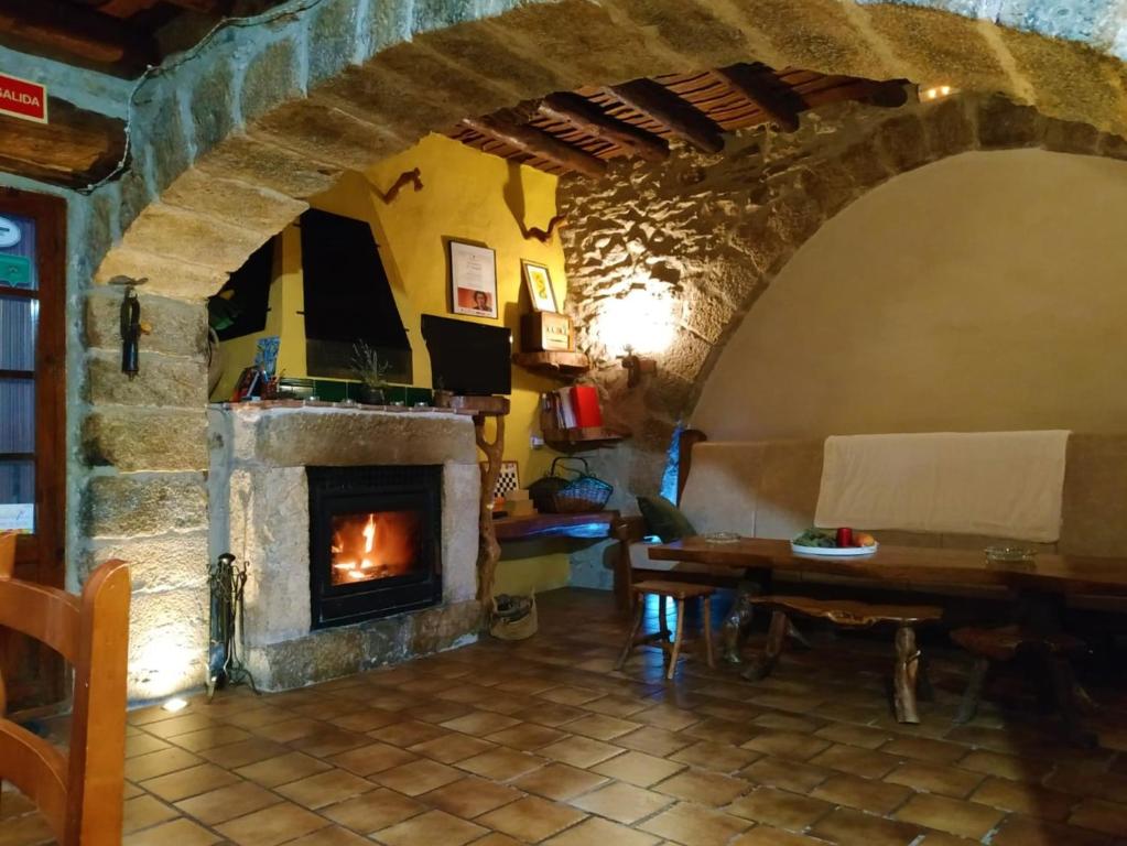 un soggiorno con camino e tavolo di Rustic Oh, casa para grupos a Xert