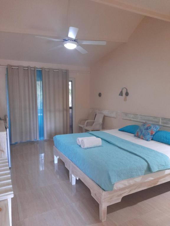 a bedroom with a large bed with a ceiling fan at guest house MY WAY in Las Terrenas