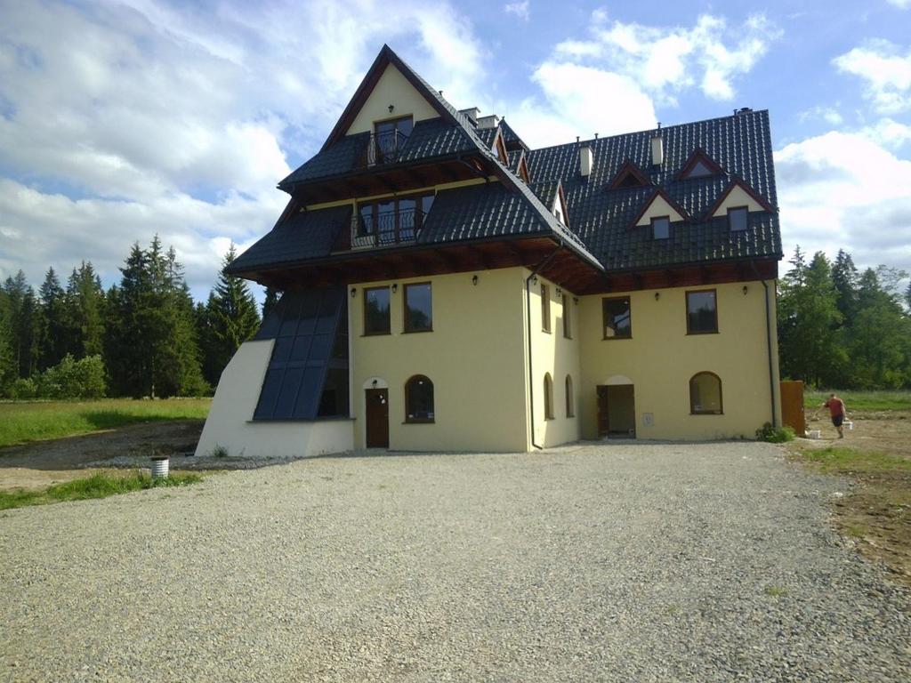 a house with a gambrel roof on top of it at Willa Pawlikowskich in Poronin