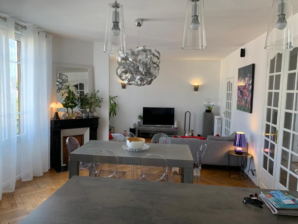 sala de estar con mesa y sofá en Appartement de charme 77 m2 proche commodités, en Chamalières