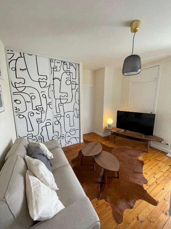sala de estar con sofá y TV en Hyper centre : Appart ancien rénové / tout confort en Clermont-Ferrand