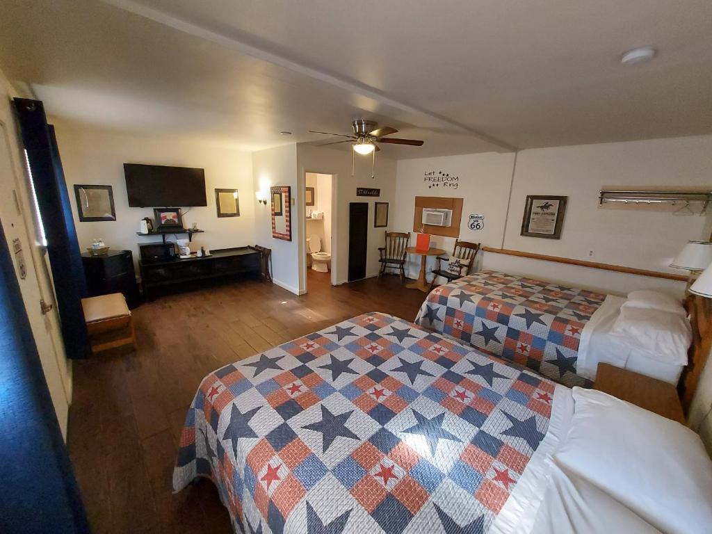 um quarto de hotel com duas camas e uma televisão de ecrã plano em Cactus Inn em McLean